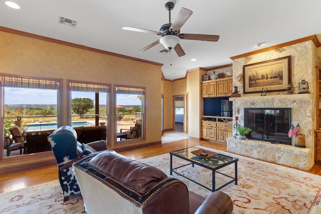 647 Funf Kinder Road Fredericksburg, TX 78624 - Photo 28 of 100 a living room with furniture a flat screen tv and a fireplace