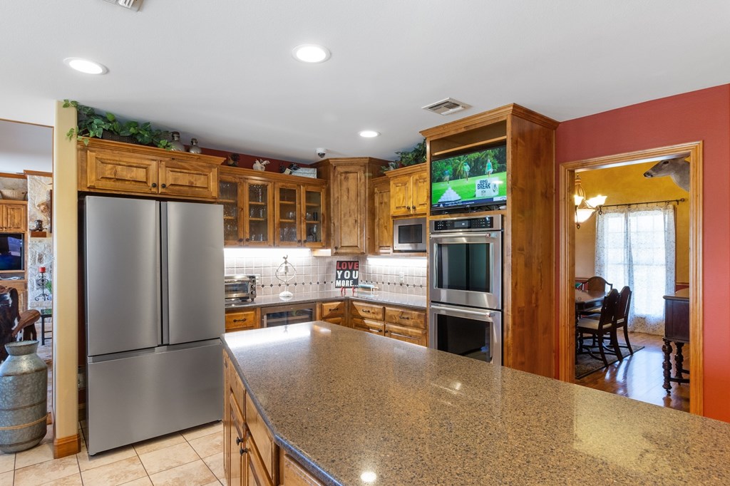 647 Funf Kinder Road Fredericksburg, TX 78624 - Photo 32 of 100 a kitchen with stainless steel appliances granite countertop a refrigerator and a stove
