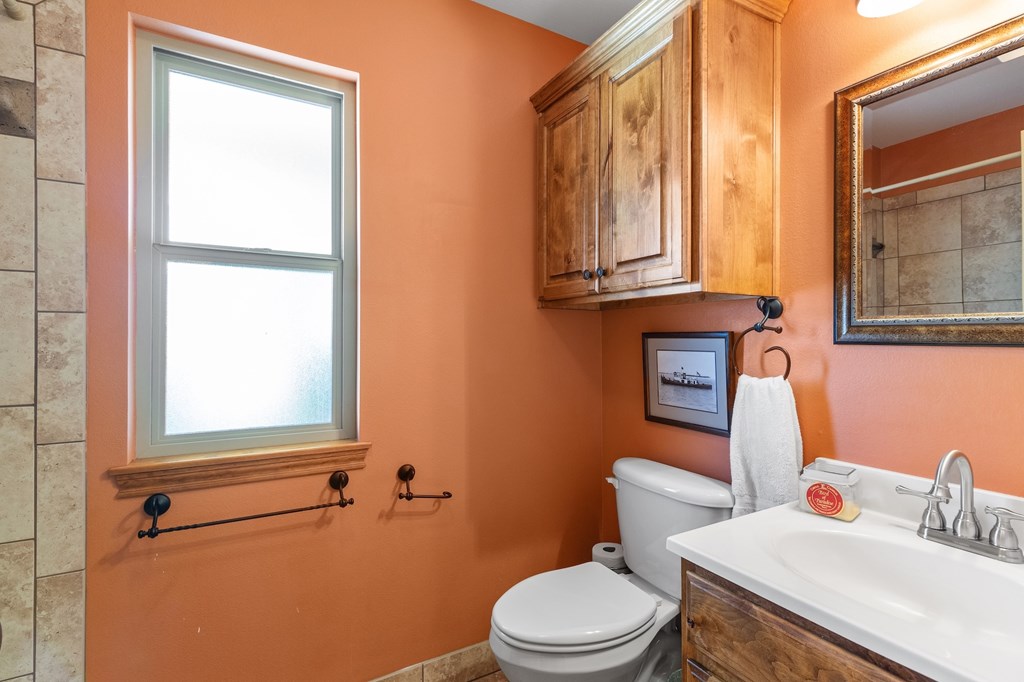 647 Funf Kinder Road Fredericksburg, TX 78624 - Photo 60 of 100 a bathroom with a toilet a sink and a window