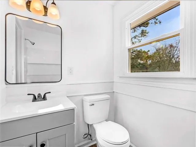 a bathroom with a toilet a sink and mirror