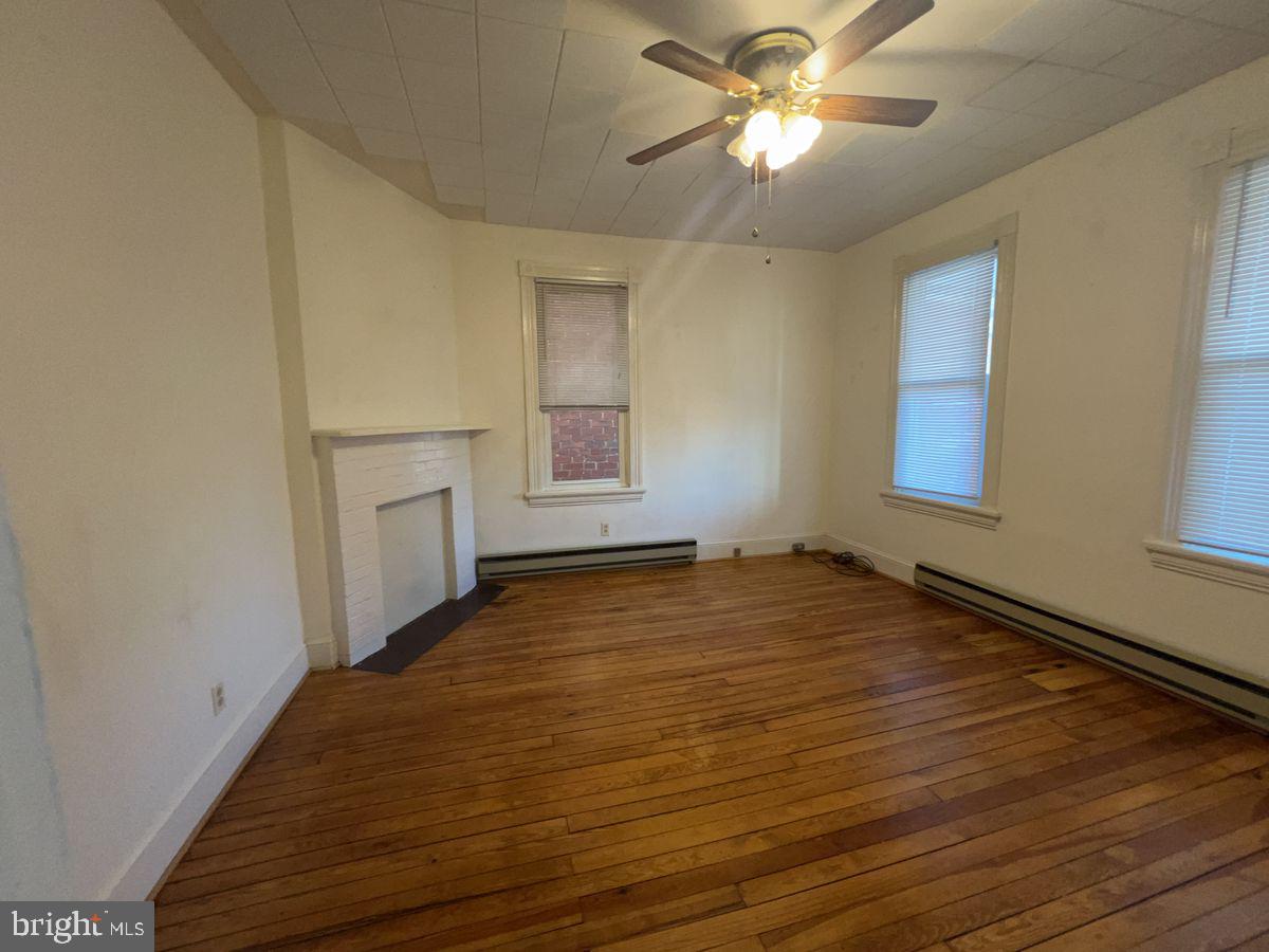 224 South Carroll Street, Unit 1 Frederick, MD 21701 - Photo 3 of 12 a view of empty room with wooden floor and fan