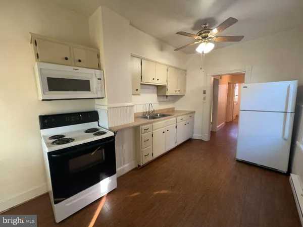 a kitchen with stainless steel appliances white cabinets and a stove top oven