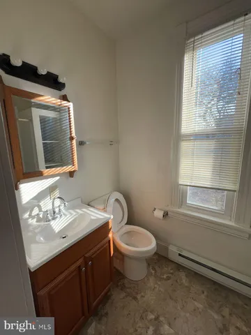 a bathroom with a sink toilet and window