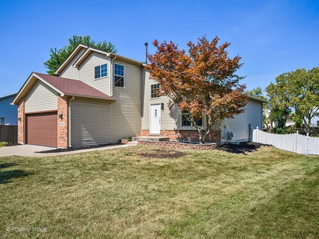 a front view of a house with a garden and yard