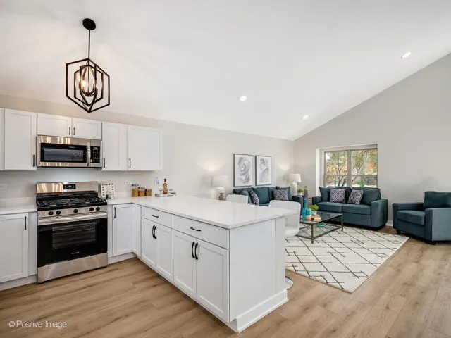 a view of kitchen with stove microwave and cabinets