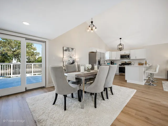a view of a dining room with furniture a chandelier and wooden floor
