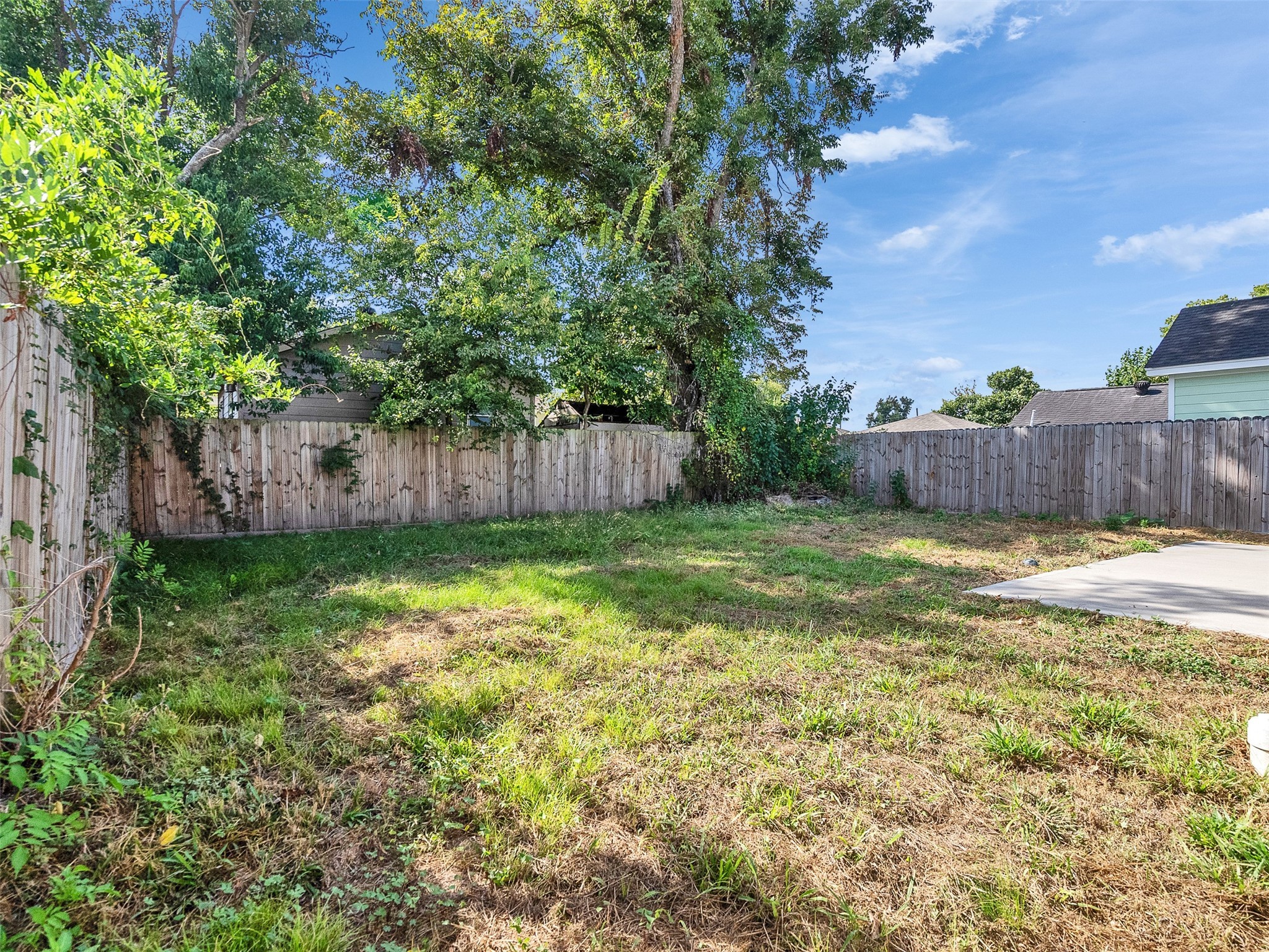 6802 Force Street Houston, TX 77020 - Photo 25 of 31 a view of a backyard with a large tree and wooden fence