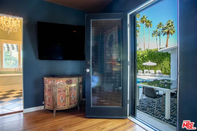 a room with a black white checkered floor with a gaming machine and dining table