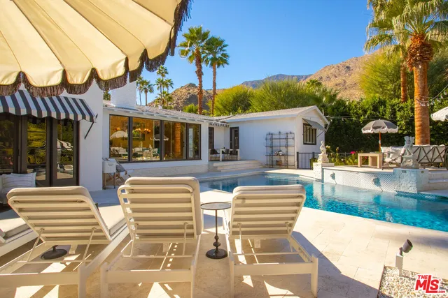 a view of a house with pool and chairs