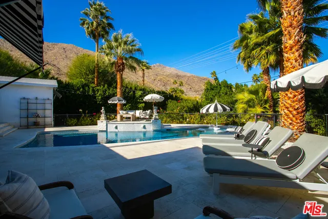 a front view of a house with a yard and a tree