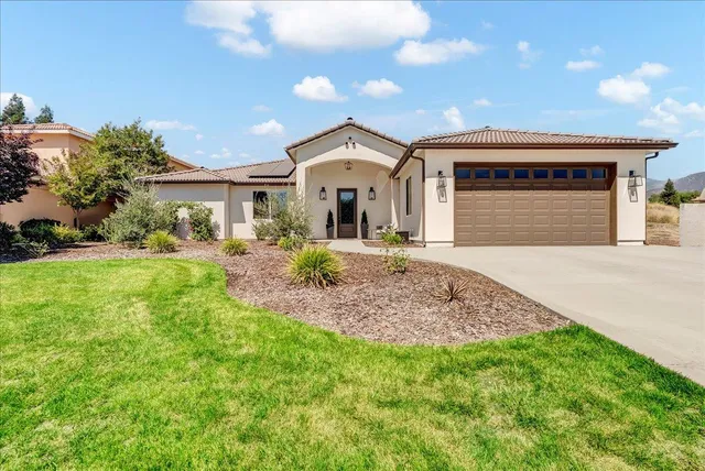 a front view of a house with a yard and garage
