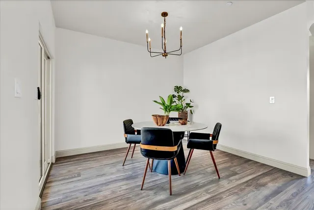 a dining room with furniture a chandelier and wooden floor