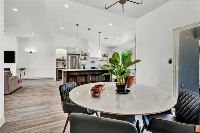 a dining room with furniture a potted plant and wooden floor