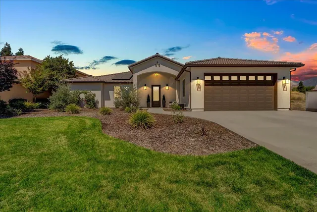 a front view of a house with a yard and garage