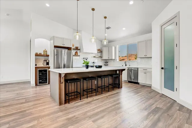 a kitchen with stainless steel appliances kitchen island a refrigerator a sink and a stove