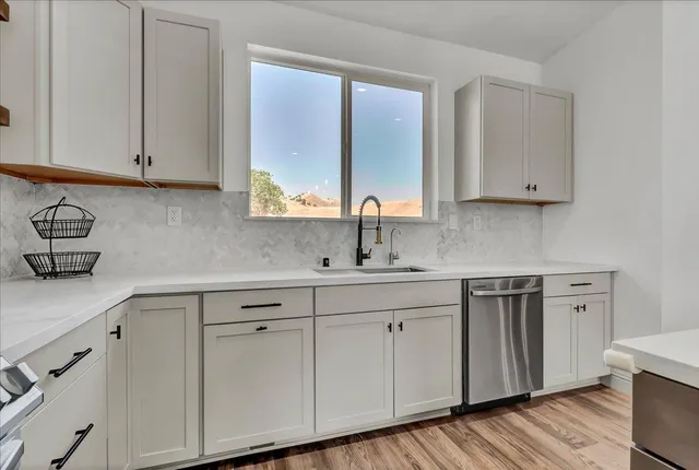 a kitchen with white cabinets white appliances and sink