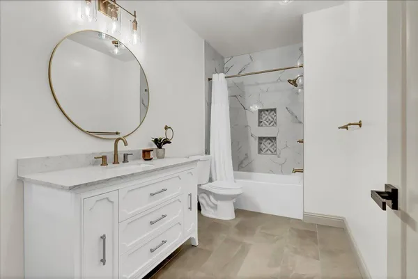 a bathroom with a double vanity sink a toilet and a mirror