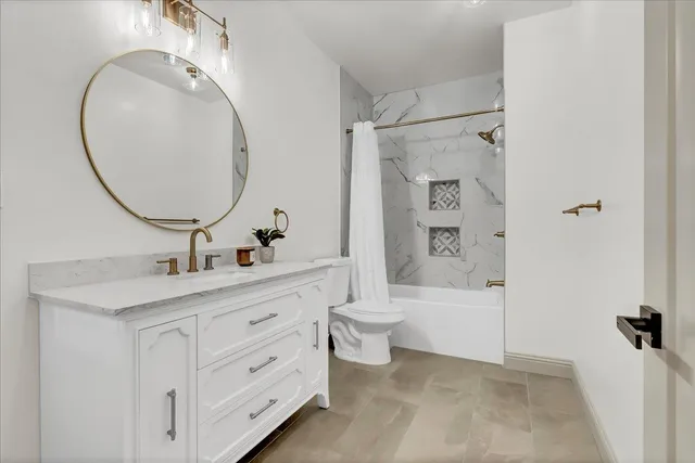 a bathroom with a double vanity sink a toilet and a mirror