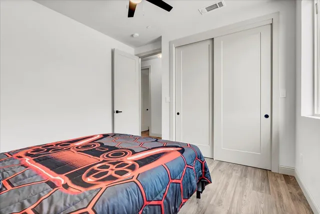 a bedroom with a bed and wooden floor