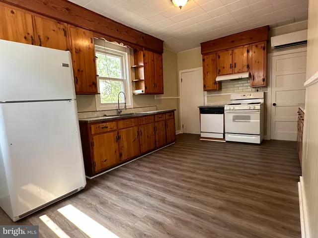 a kitchen with stainless steel appliances granite countertop a refrigerator a sink and dishwasher with wooden floor