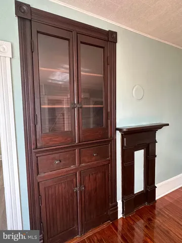 a view of an empty room with wooden floor & closet
