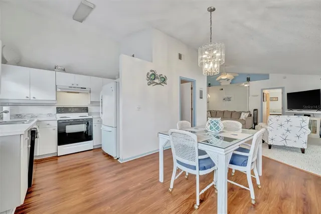 a view of a dining room with furniture wooden floor and chandelier