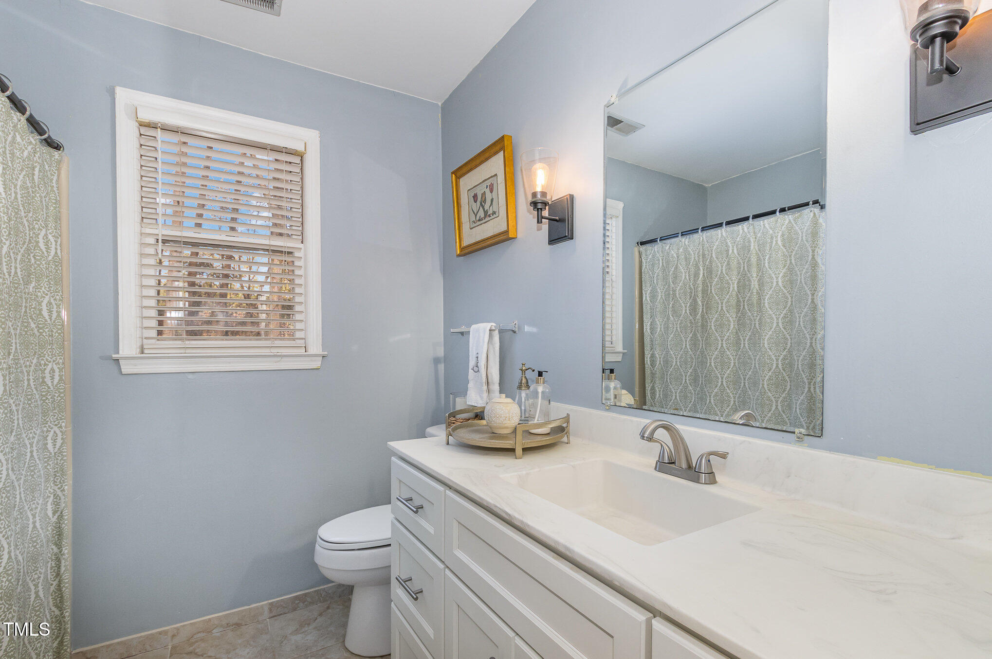 401 Rosehaven Drive Raleigh, NC 27609 - Photo 19 of 26 Upstairs hall bath has a tub/shower and generously sized vanity.