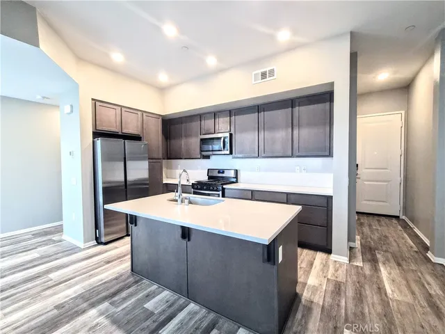 a large kitchen with kitchen island a sink stainless steel appliances and cabinets