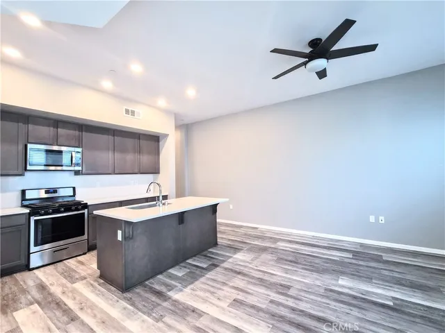 a kitchen with stainless steel appliances granite countertop a sink a stove and a refrigerator