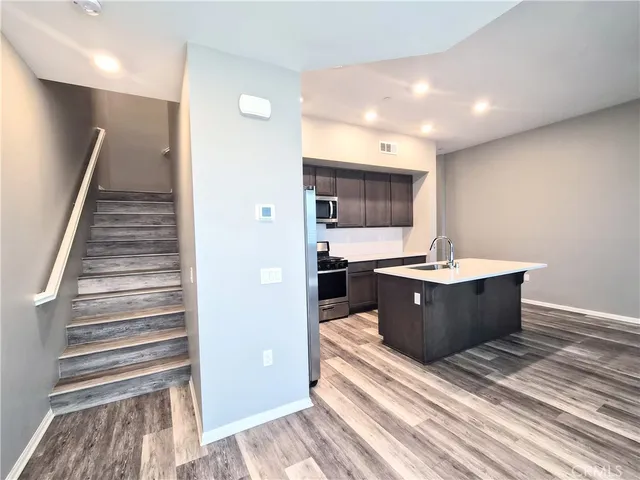 a view of kitchen with stainless steel appliances granite countertop sink
