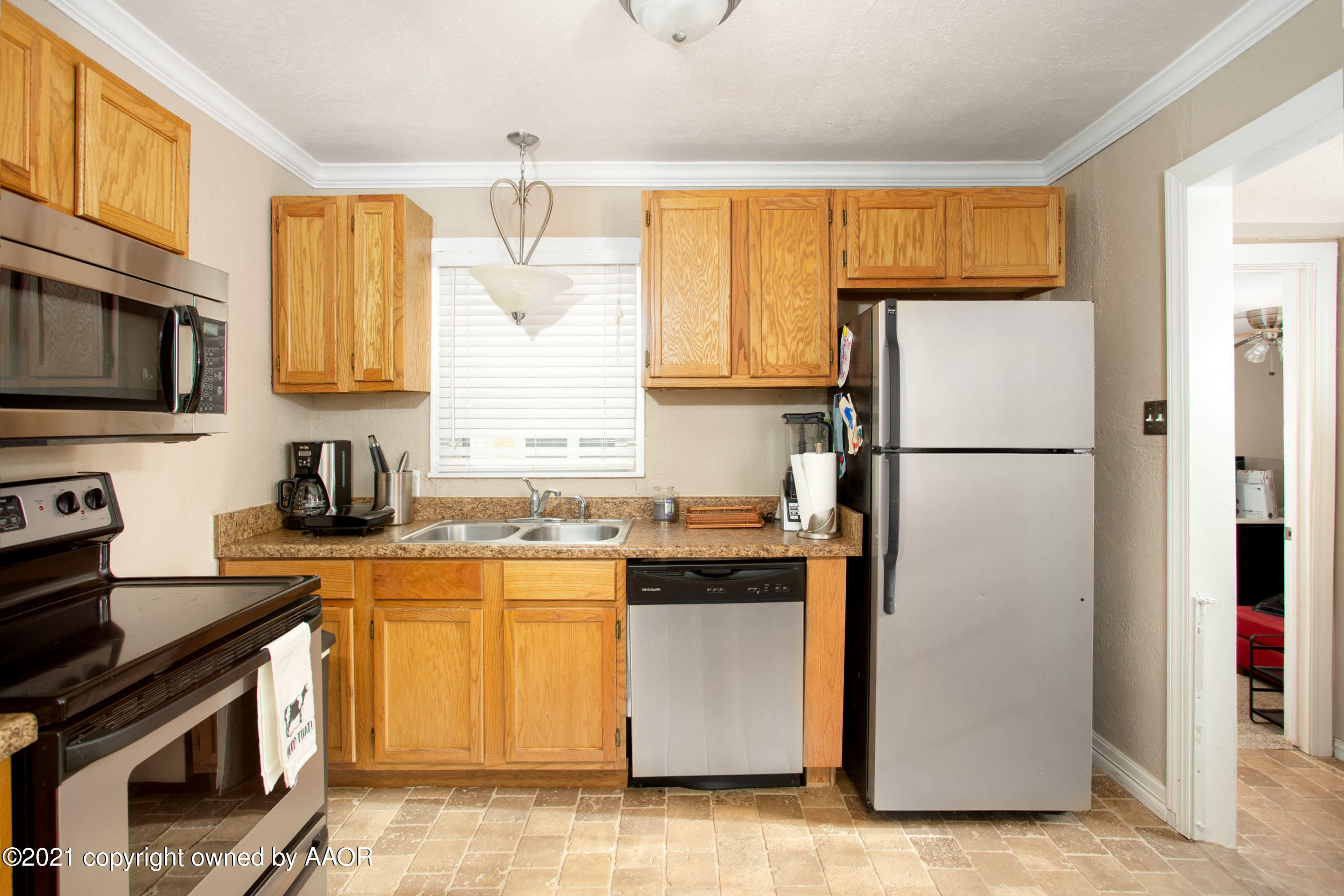 4209 South Jackson Street Amarillo, TX 79110 - Photo 6 of 18 a kitchen with a refrigerator a stove top oven a sink and cabinets