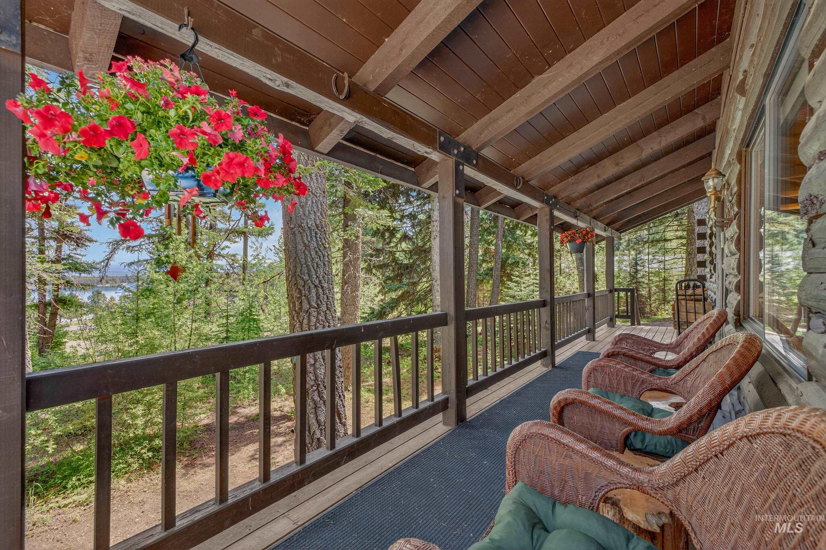 2339 West Mountain Road Donnelly, ID 83615 - Photo 7 of 37 Covered porch featuring a natural wood ceiling, exposed beams, and a log cabin style exterior