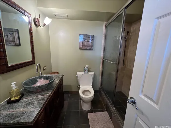 a bathroom with a granite countertop sink toilet and shower