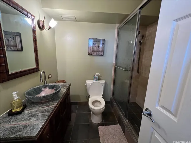 a bathroom with a granite countertop sink toilet and shower