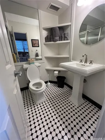 a bathroom with a sink toilet and a mirror
