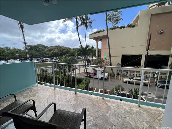 a view of a balcony with chairs and a potted plant
