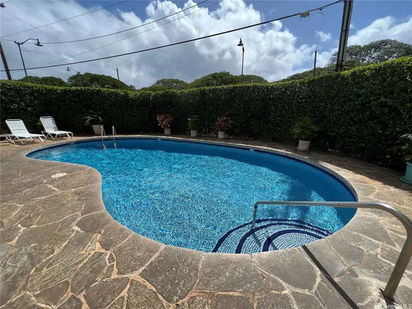 a view of a swimming pool with a patio and plants
