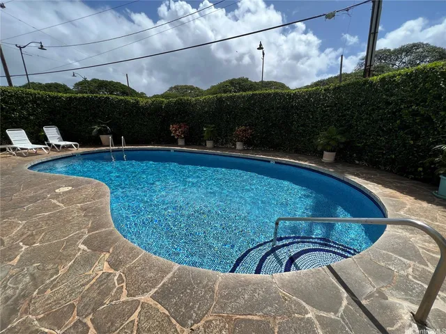 a view of a swimming pool with a patio and plants
