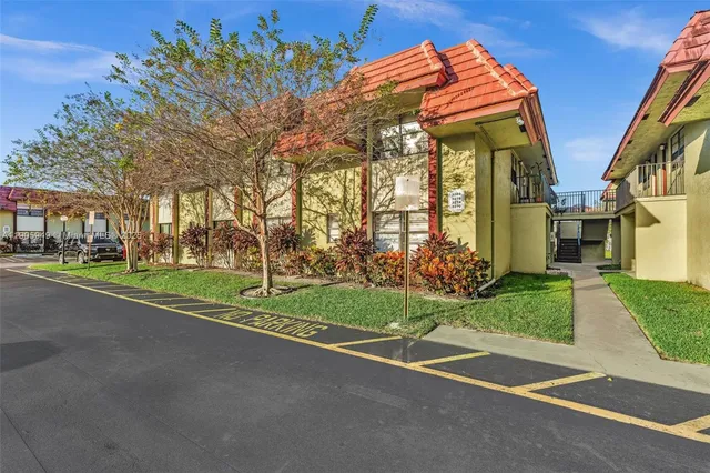 a view of a house with a big yard and large trees