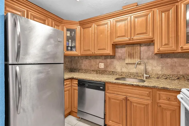 a kitchen with stainless steel appliances granite countertop a refrigerator sink and cabinets
