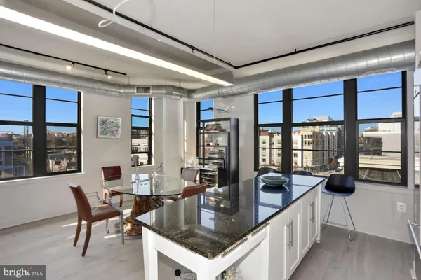 a kitchen with a table chairs and wooden floor