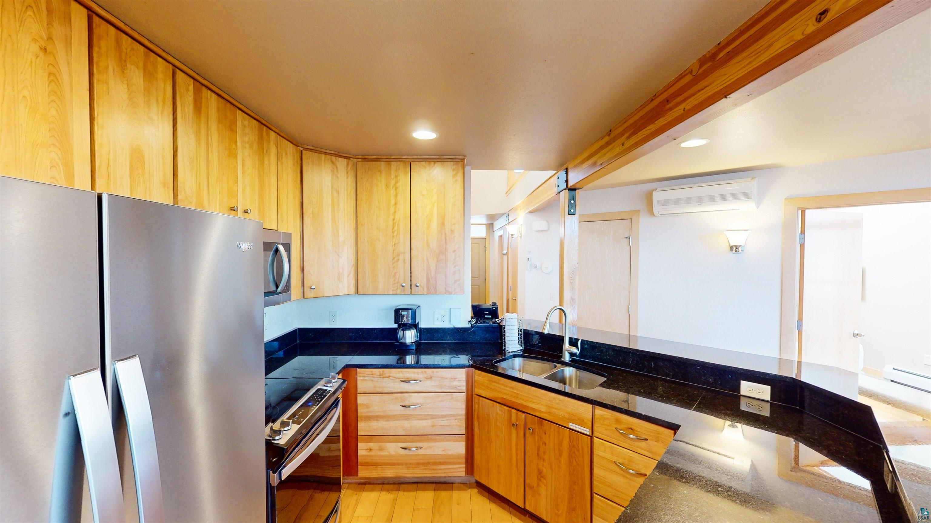 40 Surfside Drive, Unit 5D Tofte, MN 55615 - Photo 10 of 37 Kitchen featuring wood cabinetry, dark countertops, stainless steel appliances, and a built-in sink with a gooseneck faucet