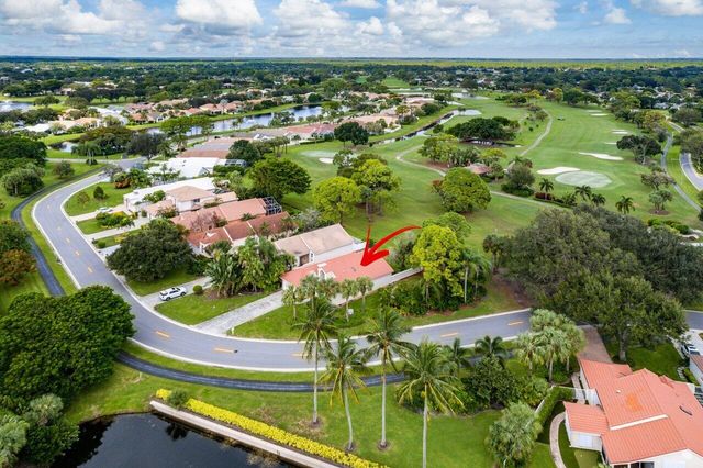 an aerial view of a residential houses with a yard and lake view