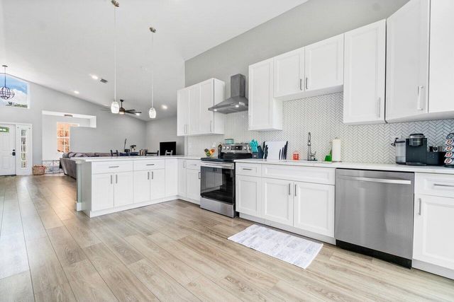 a kitchen with cabinets a sink and wooden floors
