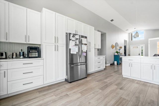 a kitchen with white cabinets and stainless steel appliances