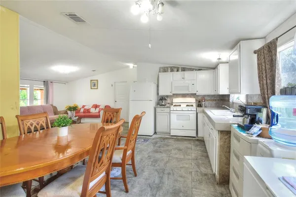 a kitchen with a table chairs stove and cabinets