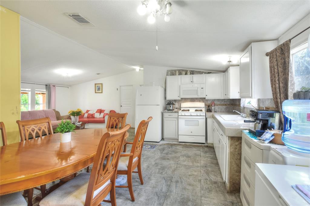 730 McClellan Road Frostproof, FL 33843 - Photo 22 of 50 a kitchen with a table chairs stove and cabinets