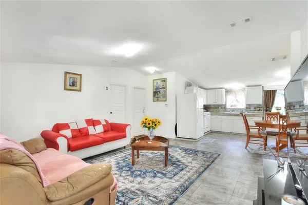 a living room with furniture and kitchen view