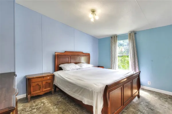 a bedroom with a bed and a larger window