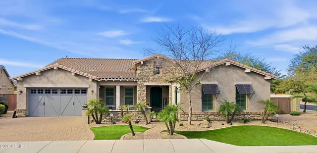 a front view of a house with a garden and plants